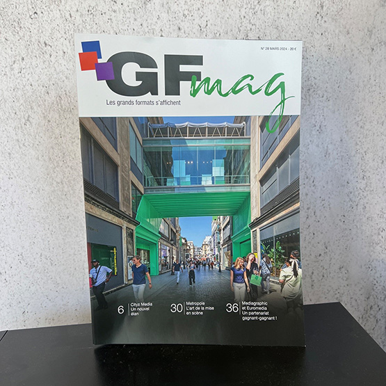 Photo de la couverture du GF Mag d'Avril 2024 avec photo d'une galerie en verre avec vitrophanie verte dans une rue à Paris